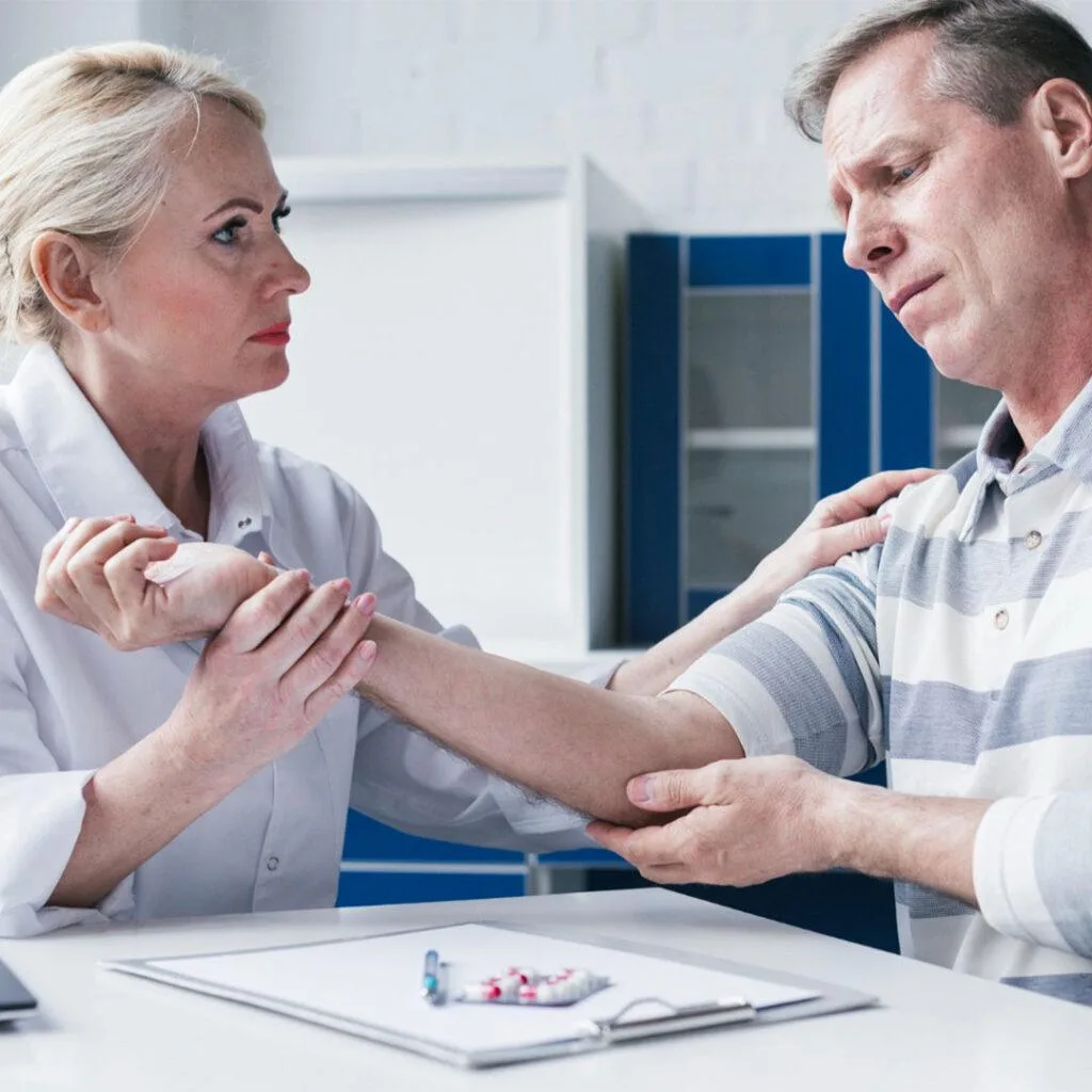 Doctor examining a patient’s arm during a clinical assessment