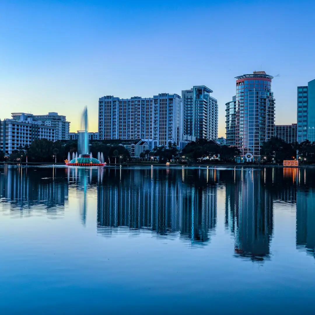 Orlando city skyline with buildings reflected on the lake at sunrise