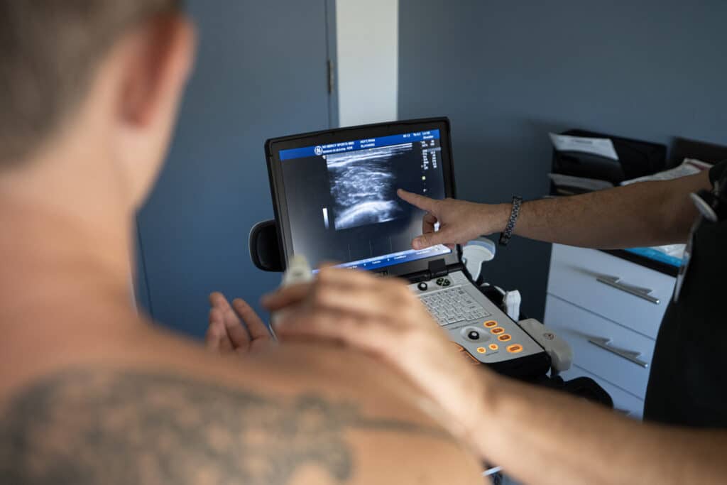 Home 2026 5 An instructor points to the ultrasound screen while a provider scans a patient's shoulder