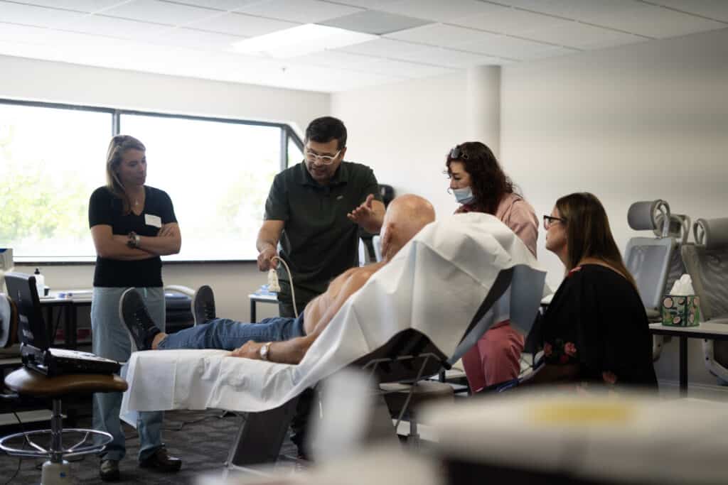 Platelet Rich Plasma (Prp) For Aesthetics And Hair Loss 6 An instructor demonstrates an ultrasound scan on a patient while three providers watch