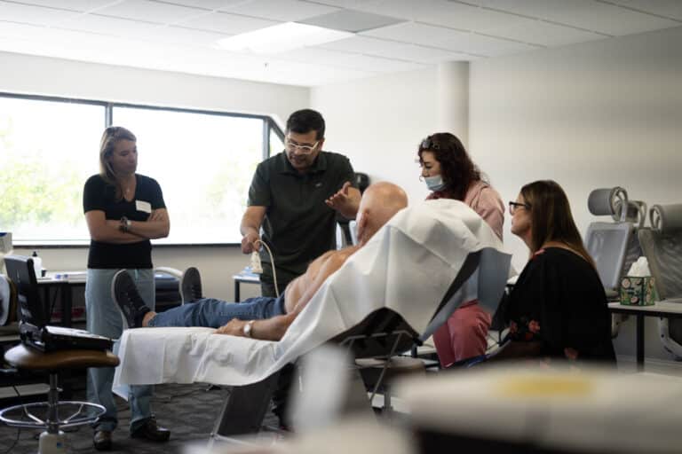 Bio-Fillers With Plasma Gel Course 6 An instructor demonstrates an ultrasound scan on a patient while three providers watch