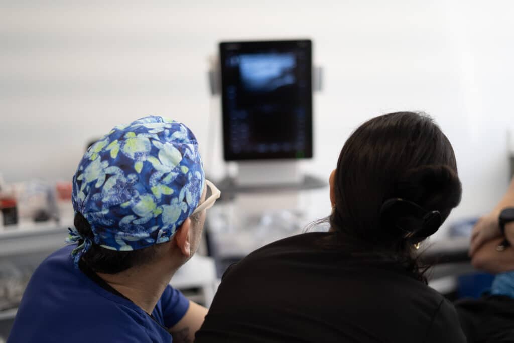 Our Story 7 An instructor and a provider watch the ultrasound screen together during a private training session